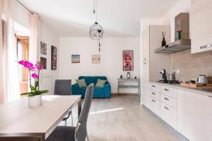een keuken en een woonkamer met een blauwe bank bij Dimora del Sole - Civico 13 in LʼAquila