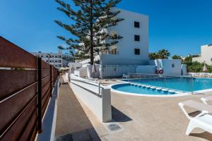 a view of a swimming pool and a fence at Pierre & Vacances Ros Ibiza in Santa Eularia des Riu