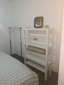 a white dresser with a mirror and a bed at Al piccolo borgo in Trevignano Romano