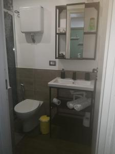 a bathroom with a toilet and a sink and mirror at Al piccolo borgo in Trevignano Romano