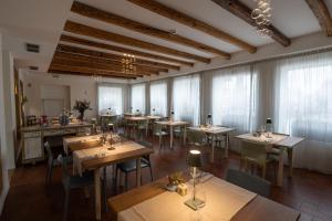 蘇塞加納的住宿－Locanda GIOVI CA' DI PONTE，餐厅设有木桌、椅子和窗户。