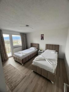twee bedden in een kamer met een groot raam bij Villa Durmic in Sarajevo