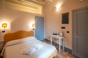 1 dormitorio con 1 cama con 2 toallas en B&B Porta Perugina en Bevagna