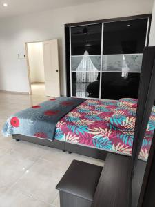 a bedroom with a large bed with a colorful comforter at Casa Margosa Homestay in Ipoh