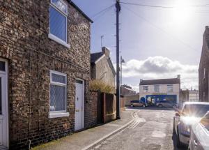 a brick building with a car parked on a street at House in Malton in Norton