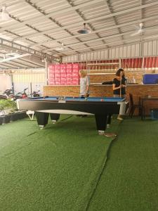 deux femmes debout devant une table de billard dans l'établissement Paradise Cozy Guesthouse Sihanoukville, à Sihanoukville