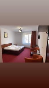 1 dormitorio con 1 cama grande y 2 sillas en Hotel Elyon Dej en Dej