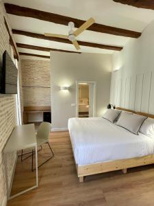 a bedroom with a bed and a ceiling fan at Cosy Rooms Embajador in Valencia