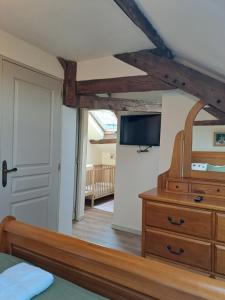 ein Schlafzimmer mit einer Kommode und einem TV an der Wand in der Unterkunft Chateau de Chambres Mont St Michel in Saint-James