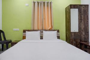 Un dormitorio con una cama grande y una ventana en Hotel Mango Tree Lodging, en Pune