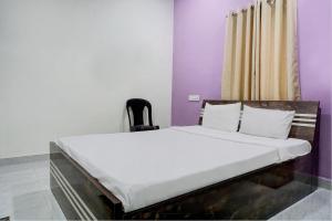 Cama en habitación con paredes moradas en Hotel Mango Tree Lodging, en Pune