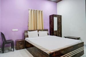 1 dormitorio con 1 cama y 1 silla en Hotel Mango Tree Lodging, en Pune