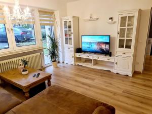 ein Wohnzimmer mit einem Flachbild-TV und einem Tisch in der Unterkunft Schöne Ferienwohnung im Schwarzwald in Bad Herrenalb