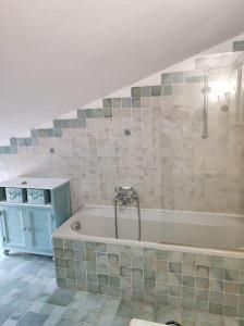 La salle de bains est pourvue d'une baignoire et d'une douche. dans l'établissement MADDy's HOUSE, à La Maddalena