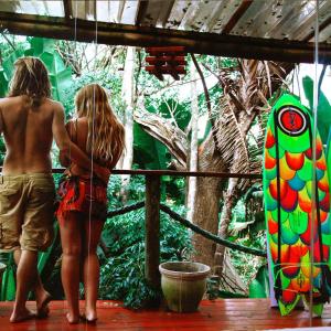 two young people are looking at a tree at Mantis and Moon Surf Paradise & Adventure Lodge in Hibberdene