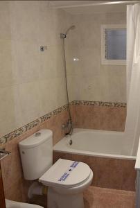 a bathroom with a toilet and a bath tub at Ritual Sevilla, piedra preciosa in Seville