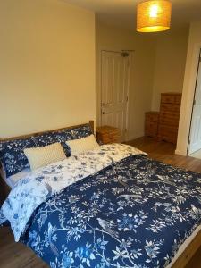 a bedroom with a bed with a blue and white comforter at Highly Comfortable Home in Hatfield
