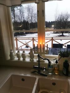 a kitchen sink with a window with snow outside at Stor Familjegård i bra läge in Finström