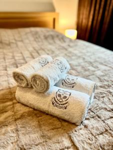 una pila de toallas sentadas encima de una cama en Karlov Dvor apartmány, en Trnava