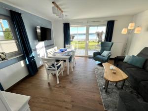 un salon avec un canapé, une table et des chaises dans l'établissement Haus mit Seeblick, gratis Nutzung vom AHOI Erlebnisbad und Sauna in Sellin - Fährhaus Sellin Nr 14, à Sellin