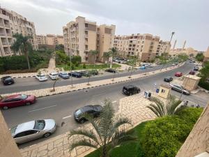 ruchliwa ulica miejska z samochodami zaparkowanymi na drodze w obiekcie شقة مفروشةومريحةفي مدينتي قريبة من كل الخدمات والحركة w mieście Madinaty