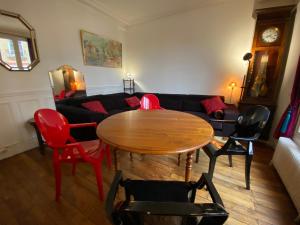 a living room with a table and chairs and a couch at Jolie appartement 4 pièces in Montreuil