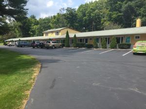 a parking lot with cars parked in front of a building at FairBridge Inn Express in Milford