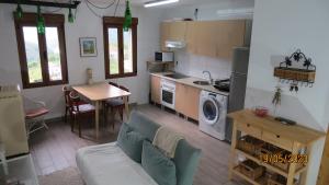 cocina y sala de estar con sofá y mesa en Casa Rural, paz y naturaleza., 