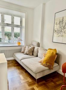 uma sala de estar com um sofá e duas janelas em Frederiksberg em Copenhague