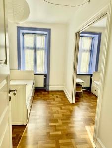 pusty pokój z łóżkiem i dwoma oknami w obiekcie Frederiksberg w Kopenhadze
