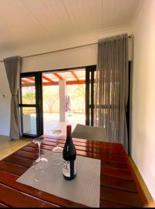 a bottle of wine sitting on a table with glasses at Bushbuck Rest in Marloth Park +52 photos
