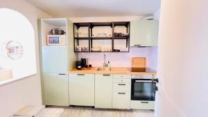 una cocina con armarios blancos y fregadero en Appart Brussels Atomium&Expo, en Grimbergen
