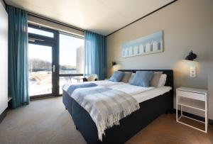 a bedroom with a large bed and a large window at StayBliss Haven Kakumäe in Tallinn