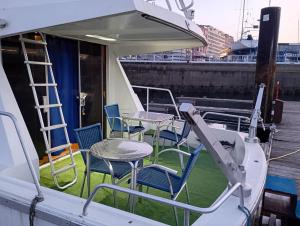 eine Gruppe von Stühlen und Tischen auf einem Boot in der Unterkunft Yate Gijon , experiencia unica J in Gijón