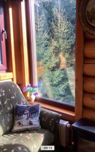 a living room with a couch and a large window at Cottage PolyaNitsa окремий котедж з каміном in Bukovel