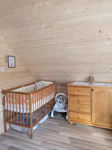 Pokój z łóżeczkiem dziecięcym i drewnianą ścianą w obiekcie Agroturystyka Przy Siole Budy w mieście Białowieża