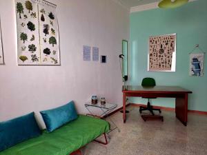 a living room with a green couch and a desk at La casa sull'albero in Palermo