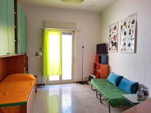 a living room with a green couch and a window at La casa sull'albero in Palermo