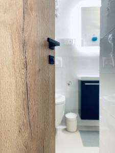 een houten deur in een badkamer met een toilet bij Astraluxe in Fažana