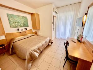 a hotel room with a bed and a desk at Hotel La Vetta Europa in Castellana Grotte