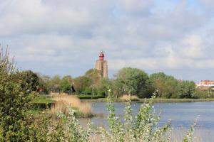 een gebouw met een klokkentoren naast een meer bij 103D nieuwe vakantiewoning met sauna in Westkapelle