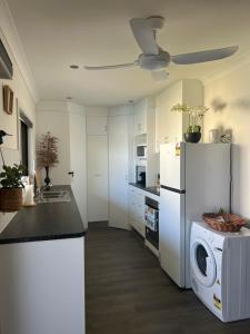 a kitchen with a refrigerator and a washing machine at Shazza’s Desert Oasis in Broken Hill