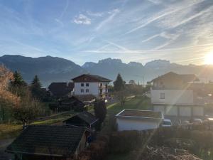 Una vista de un pueblo con montañas al fondo. en La Roseliere, en Sévrier