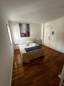 um quarto com uma cama e um quadro na parede em VHostel em Guimarães