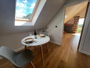 a white table and chairs in a room with a window at Larks Rise in Bruisyard