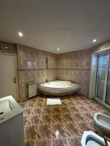 uma casa de banho com banheira no canto de um quarto em VHostel em Guimarães