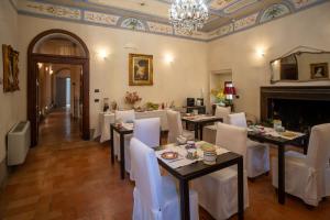 een eetkamer met tafels en stoelen en een open haard bij B&B Porta Perugina in Bevagna