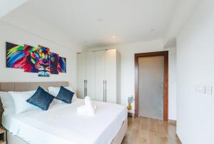a bedroom with a white bed with a painting on the wall at Rosewood luxury 1 bedroom @ Solaris in Accra