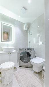 a bathroom with a washing machine and a toilet and a sink at Rosewood luxury 1 bedroom @ Solaris in Accra