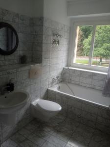 a bathroom with a tub and a toilet and a sink at ELBENLAND SÄCHSISCHE SCHWEIZ II - Komfortable 2-Raum-Wohnung im Herzen der sächsischen Schweiz in Sebnitz
